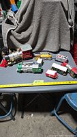 Overall view of six plastic Christmas train pieces on table with tape measure