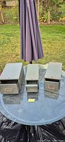 Three grey metal index card drawers on table