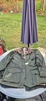Full view of front of olive waxed jacket on table