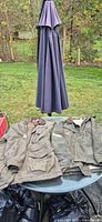 Two canvas work coats laid flat on table outdoors