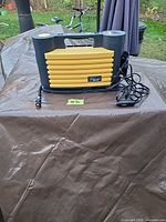 Front view showing ribbed yellow panel, power cord