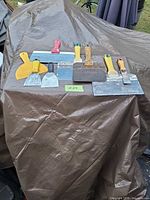 All seven scrapers laid out on tarp