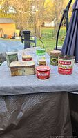 Group shot of all eight vintage tins on table