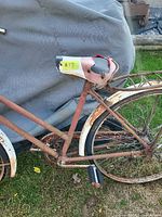 close view of rear half showing rusted frame, white fender, rear rack, saddle