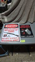 Both metal signs on table
