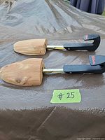 Two Wilson cedar shoe trees laid side by side showing adjustable metal shafts and logoed handles