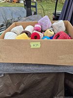 Box filled with various coloured crochet thread balls