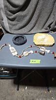 Wind chime, black marble ashtray, yellow onyx ashtray on table