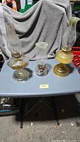 Three glass oil lamps on table