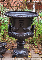 Full view of cast iron urn on pedestal base