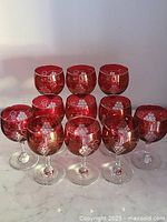 Front view of all 11 cranberry glass goblets