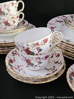 Close-up of cups and saucers showing floral pattern and gold trim