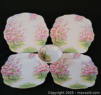 Four square plates and one round bowl arranged on black background showing pattern and shape