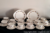 Full set laid out showing cups, saucers, cake plates, creamer, sugar bowl