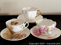 Three teacup and saucer sets displayed