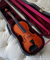 Violin inside open burgundy-lined hard case