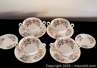 Four Wedgwood two-handled cups each on saucer plus two extra saucers