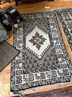 Both rugs on floor showing overall patterns and size difference