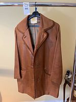 Full view of Burberry leather jacket on hanger showing front, lapel, pockets