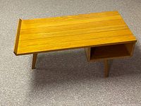 Full view of rectangular wood coffee table showing raised edge, open shelf, tapered legs, wood grain
