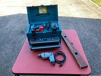 Overall view of Makita case with contents, Black & Decker drill, Stanley level