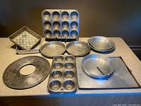 All nine vintage aluminum bakeware pieces arranged on countertop