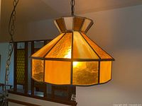 Pendant lamp illuminated, showing stained glass panels