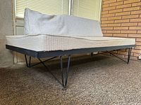 Side angle showing full sofa, hairpin legs, cushions