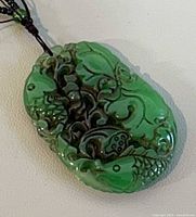 Front of carved green jade pendant