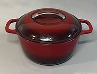 Front view of red KitchenAid Dutch oven with lid and side handles