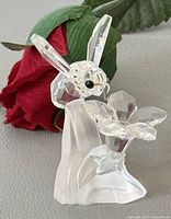 Front view of crystal bee hovering over flower on frosted base