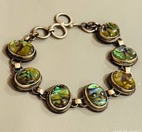 Top view showing eight abalone cabochons in silver bracelet