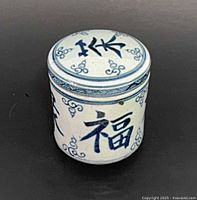 Lidded tea caddy front view showing characters and patterns