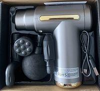 Massage gun in box with four heads and USB cable