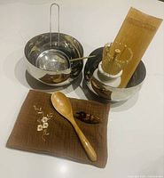 Full set showing bowls, strainer, whisk in holder, curved bamboo tray, spoon, cloth, duck figurine