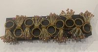 Front view of all ten beaded napkin rings on display board