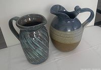 Front view of both stoneware pitchers side by side