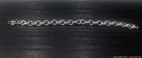 Full length view of silver link bracelet on black background