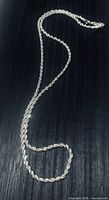 Twisted rope style sterling silver chain necklace displayed on dark background