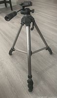 Tripod front view, legs extended, showing pan-and-tilt head and handle