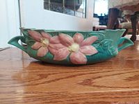 Side view showing relief magnolia decoration and both handles