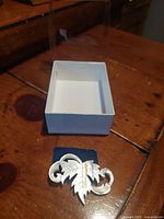 Brooch front with box lid removed showing size and accessory