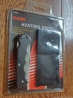 Front view of sealed Hawk hunting knife package showing knife and sheath