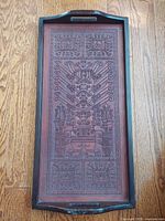 Full view of tray showing wood frame and tooled leather panel