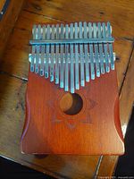 Front view of wooden kalimba showing tines and sound hole