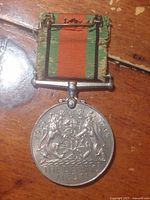 Full view of medal with ribbon showing colours and suspension bar