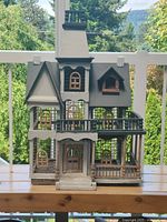 Front view of multi-storey wooden birdhouse with steps, balconies and chimney