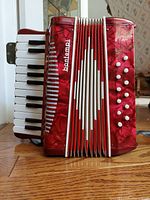 Front view of red Bontempi accordion showing keys, buttons and bellows