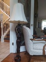 Full view of floor lamp beside chair
