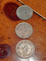 Three coins laid out showing reverse sides